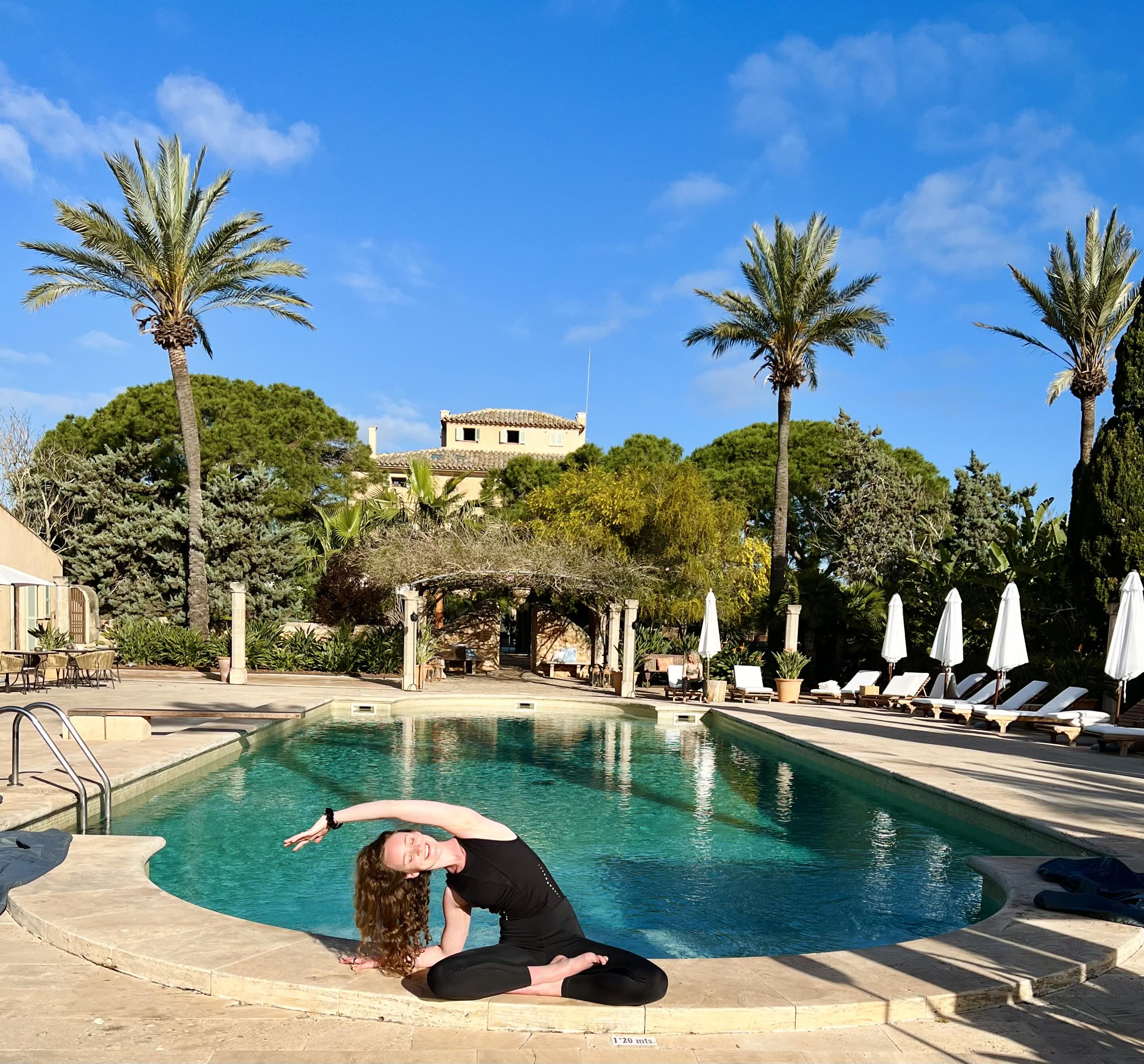 Julia doing yoga near a pool  – Sunshine Yoga